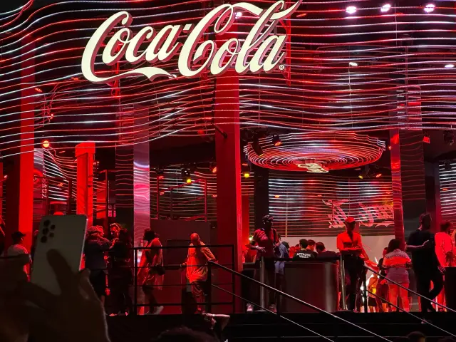 O letreiro Coca-Cola sobre o palco, à noite