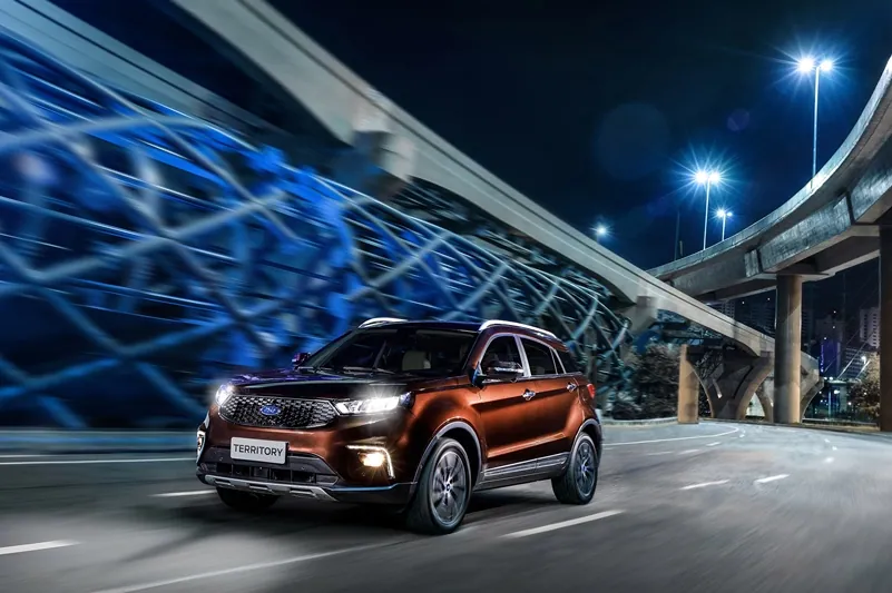Um Ford Territory em movimento sob um viaduto iluminado em azul