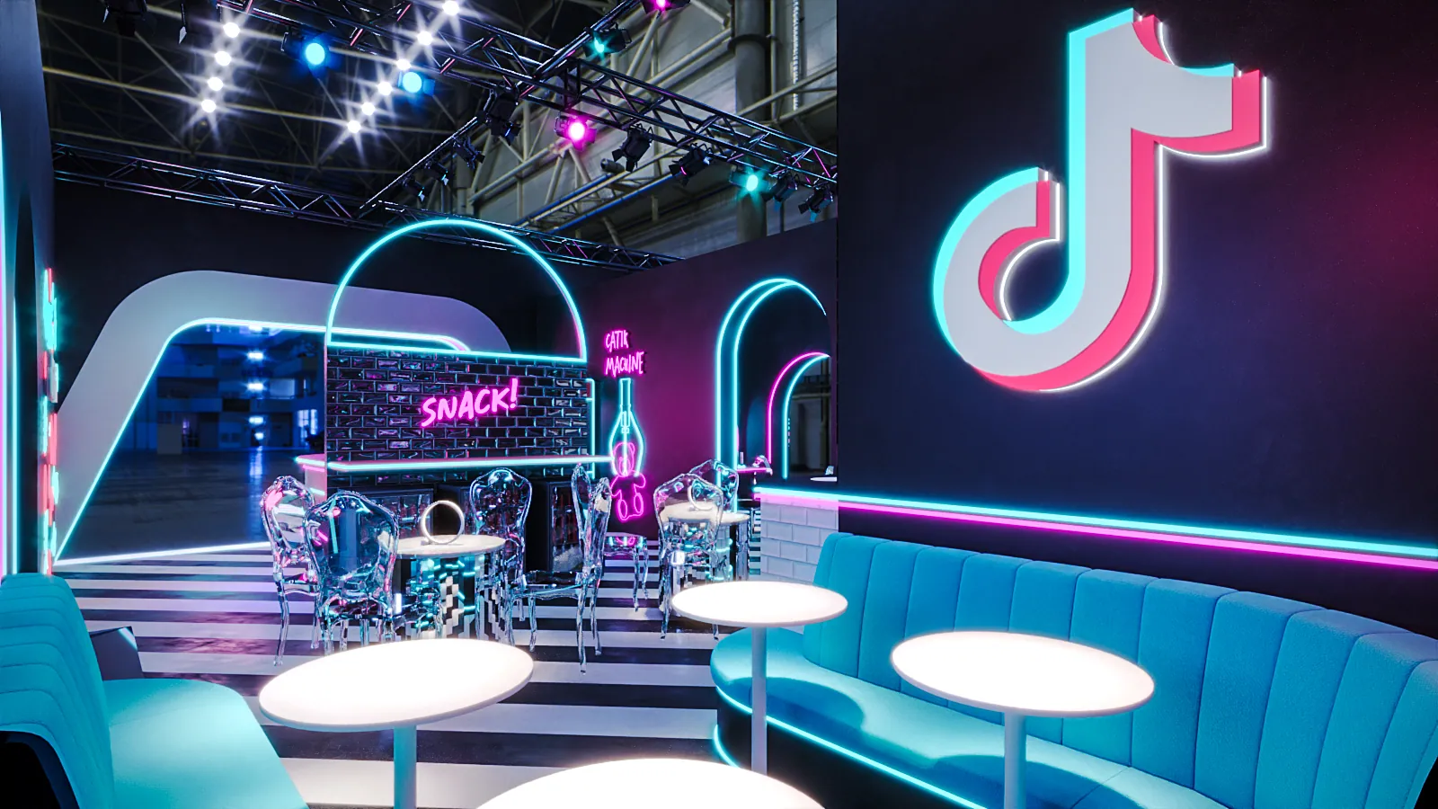 O lounge de encontro, com sofás, mesas e a nota da marca em neon na parede