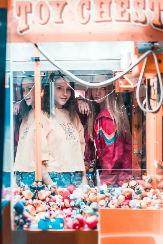 Referência visual: jovens atrás do vidro de uma claw machine