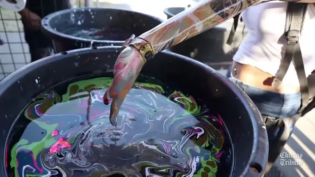 Referência visual: braço marmorizado sobre a bacia de tinta